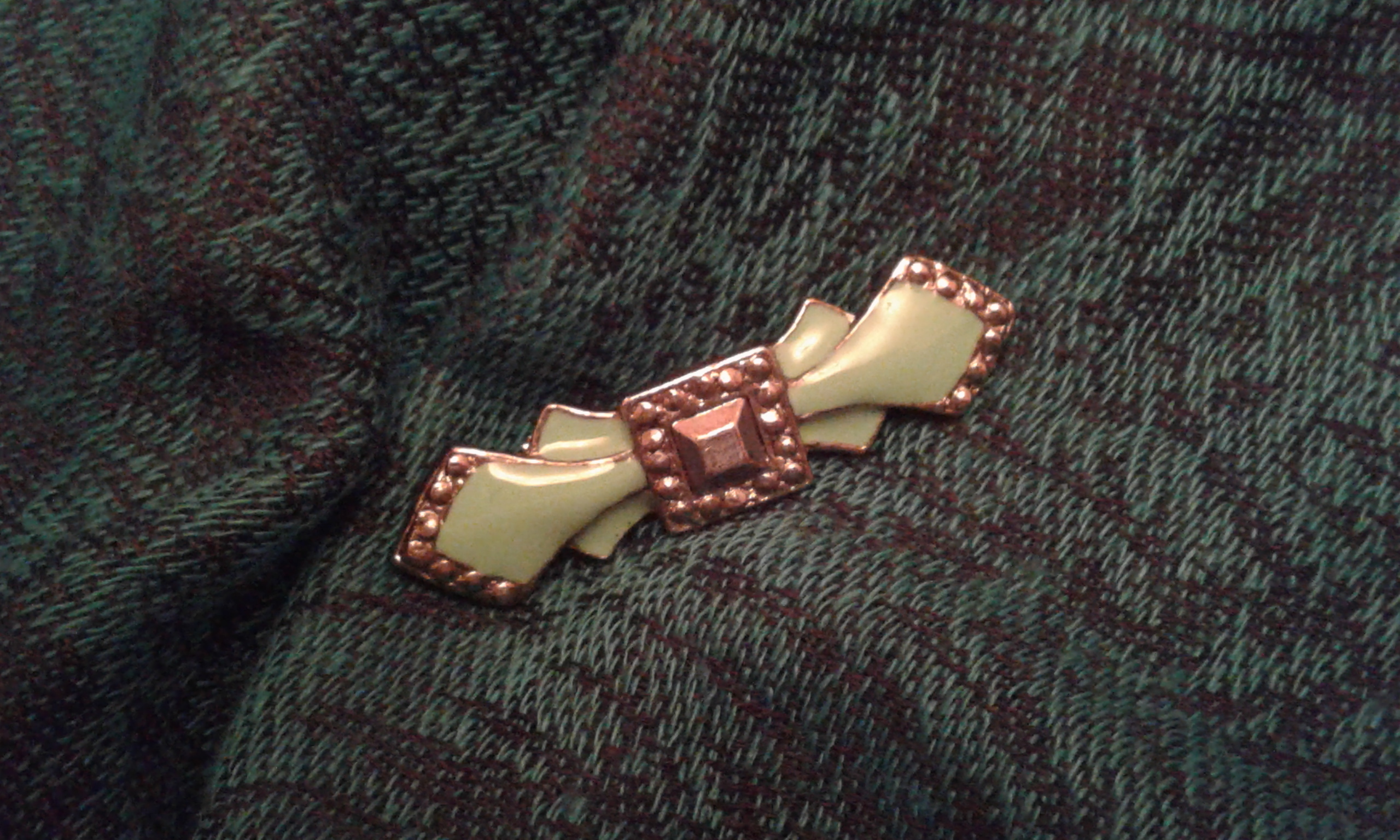 A green antique brooch on a cashmere shawl